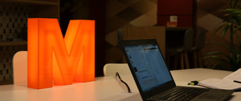 MITS Laptop vor leuchtendem M Notebook MITS davanti a M luminosa